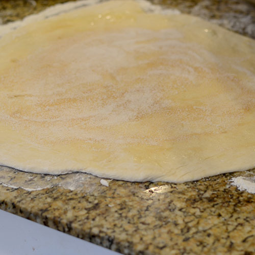 dough-rolled-out-and-sugar-and-cinnamon-added milk,vegetable oil, dry yeast, all-purpose flour, baking powder, baking soda, cinnamon, sugar, sugar, milk, butter, coffee, salt, maple extract