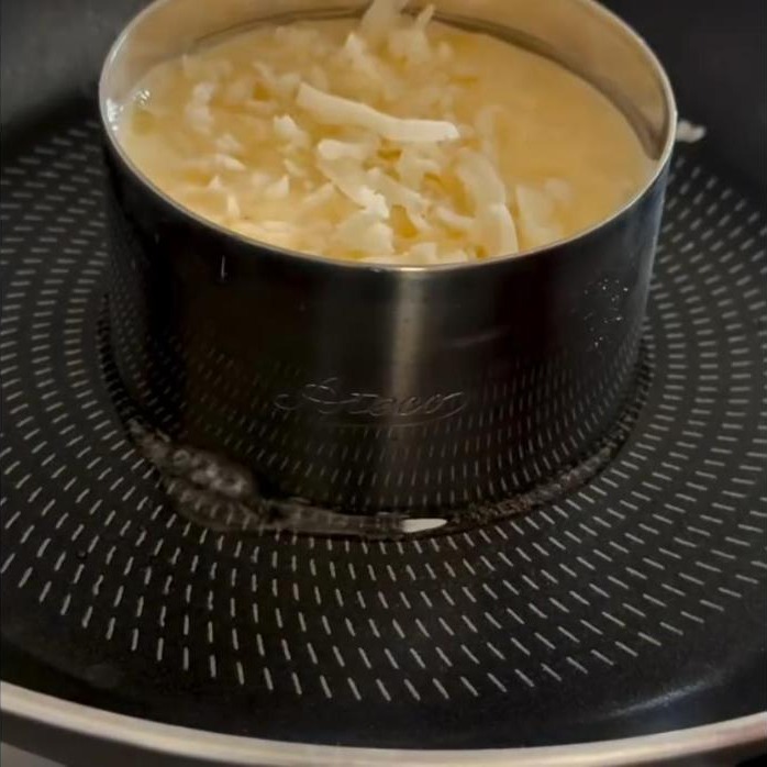 Whisked eggs and shredded cheese in a ring mold
