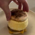 Homemade egg McMuffin with a tall steamed egg on a sourdough English muffin