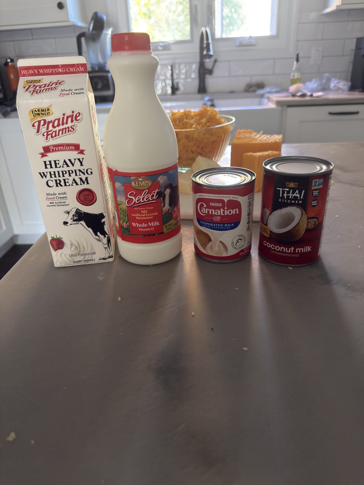 Heavy cream, whole milk, evaporated milk and coconut milk lined up for a mac and cheese taste test
