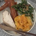 Baked mac and cheese with evaporated milk on a Thanksgiving plate with smoked turkey and green beans