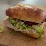 Turkey sub on a homemade sourdough roll with chopped salad, salami and melted cheese